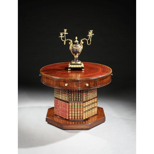 A regency mahogany revolving drum table on a bookcase pedestal